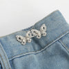 Silver floral butterfly button clips attached to a blue denim fabric