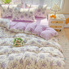 A lavender print duvet cover set with matching pillowcases displayed on a bed next to a white nightstand.