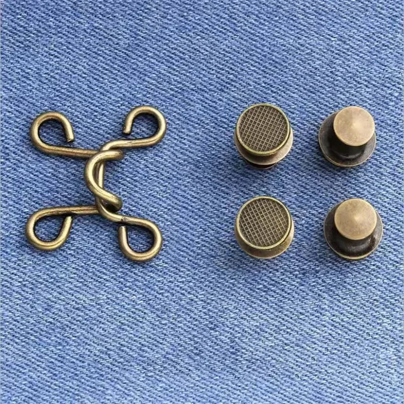 A set of brass metal button snaps, including a chain and individual buttons, displayed on blue denim fabric.