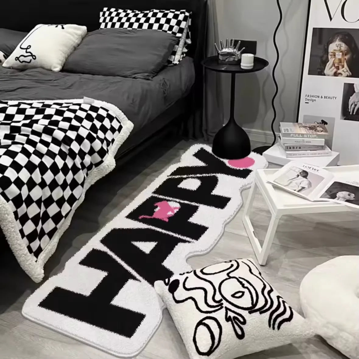 A collection of black and white patterned floor mats, including a large HAPPY mat and decorative cushion.