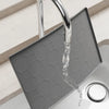 A silver faucet is visible over a gray silicone mat used as an under sink cabinet liner.