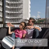 A couple relaxing indoors while looking out of a large window, demonstrating the UV protection of insulated glass film.