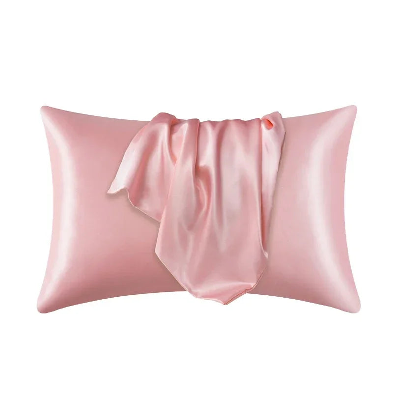 A pink luxury mulberry silk pillow cover with a draped fabric detail.