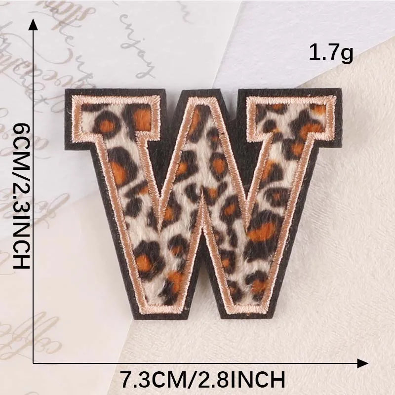 Iron-on patch of the letter W in leopard print fabric on a white background.