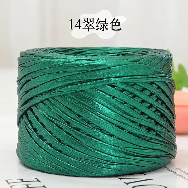 A coil of metallic green cake yarn used for crafting.
