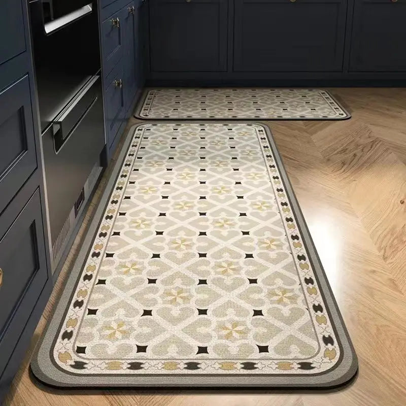 A rectangular beige and gray anti-slip floor mat placed on a light wood floor next to dark cabinetry.
