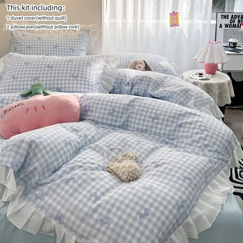 A light blue and white checkered duvet cover set with a pink elephant pillow and decorative pearls.