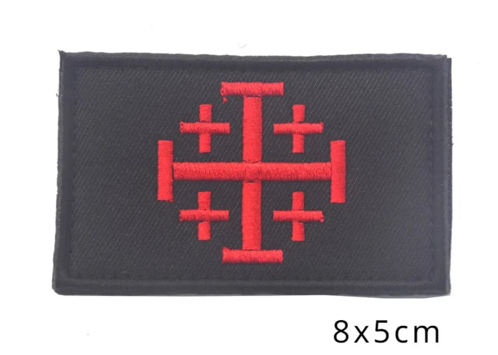 Black embroidered patch featuring a red cross design.