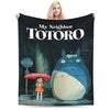 A poster featuring the Totoro character in the rain, with a woman holding it.