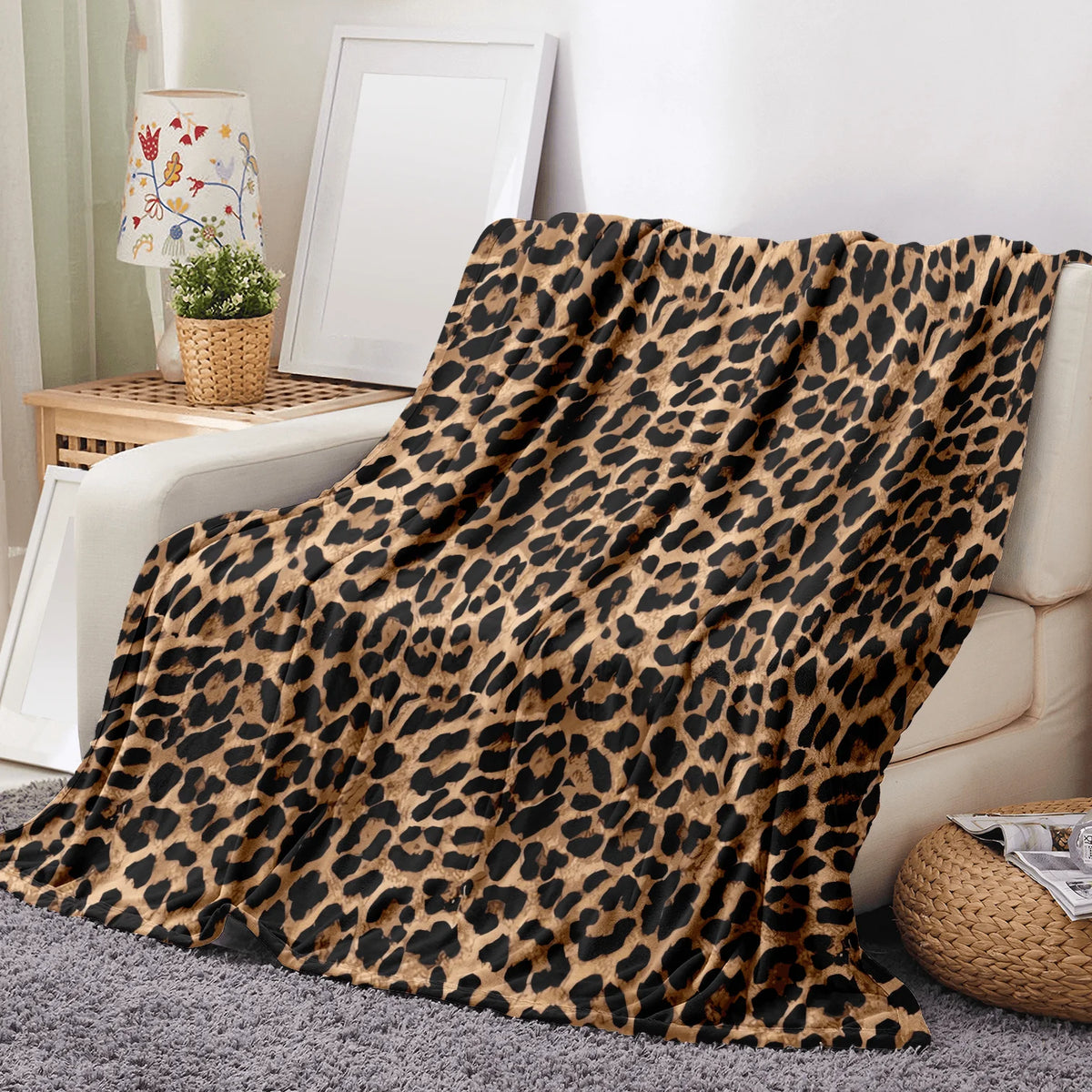 A luxurious leopard print flannel blanket draped over a light-colored sofa.