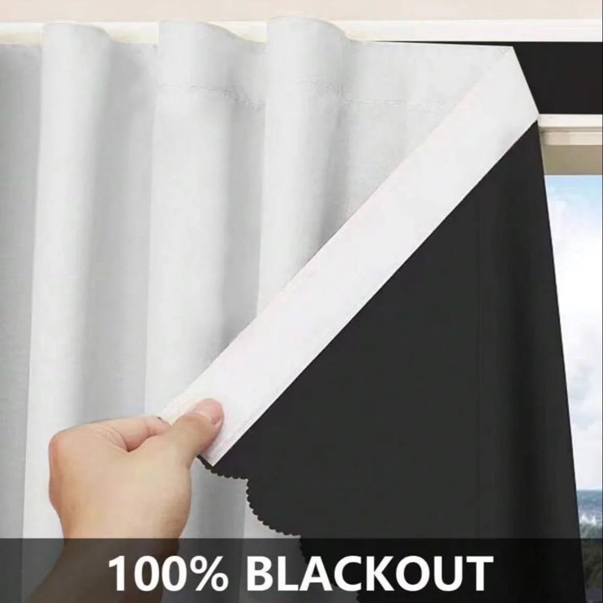 A hand is pulling a white blackout window curtain across a black fabric panel.