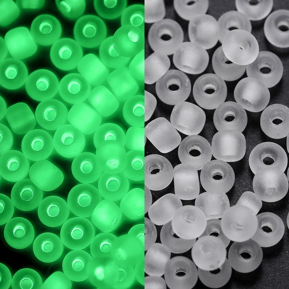 A close-up view of small, round, translucent green glow-in-the-dark glass seed beads.