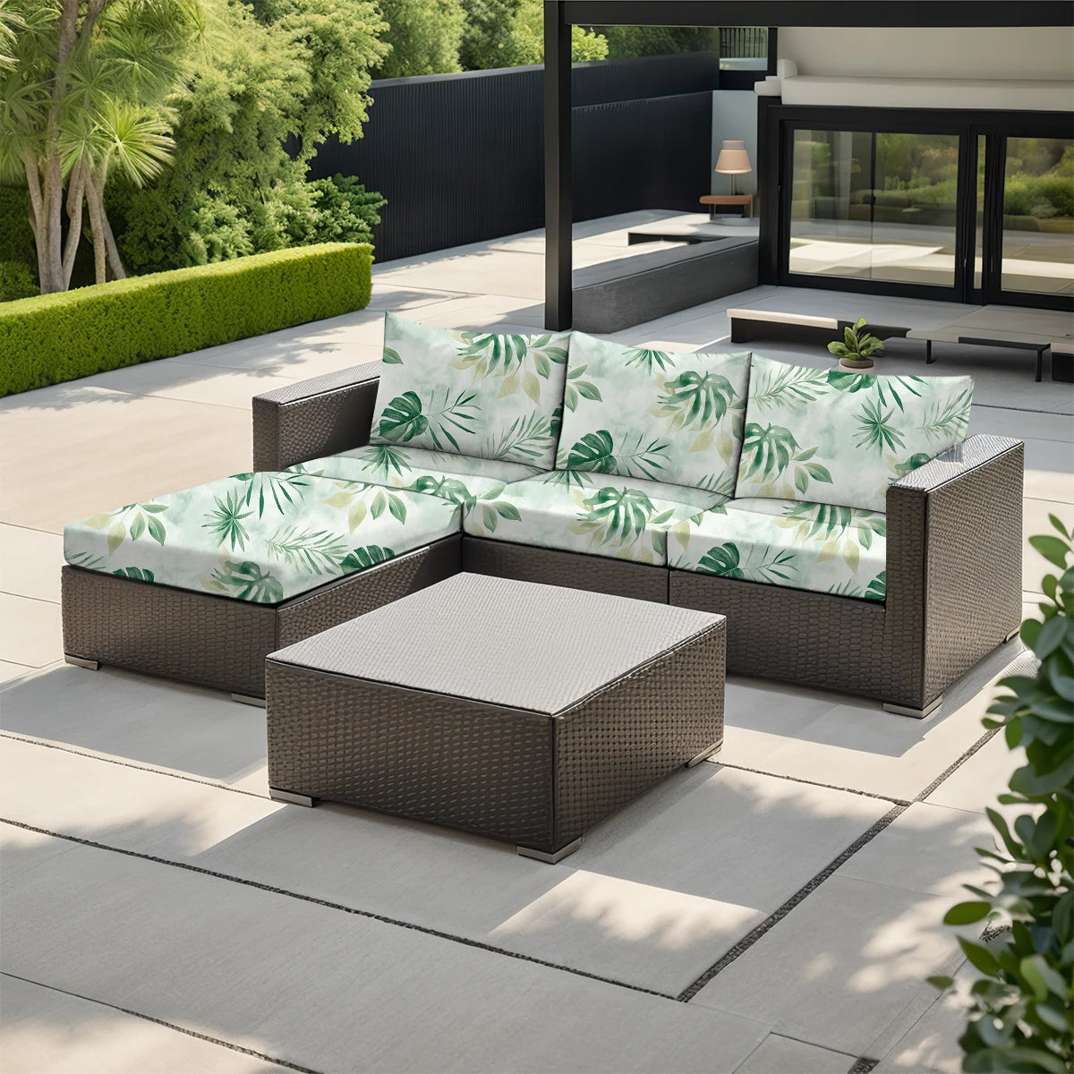 A modern outdoor sofa set featuring light green and white floral patterned cushions on a gray wicker frame.