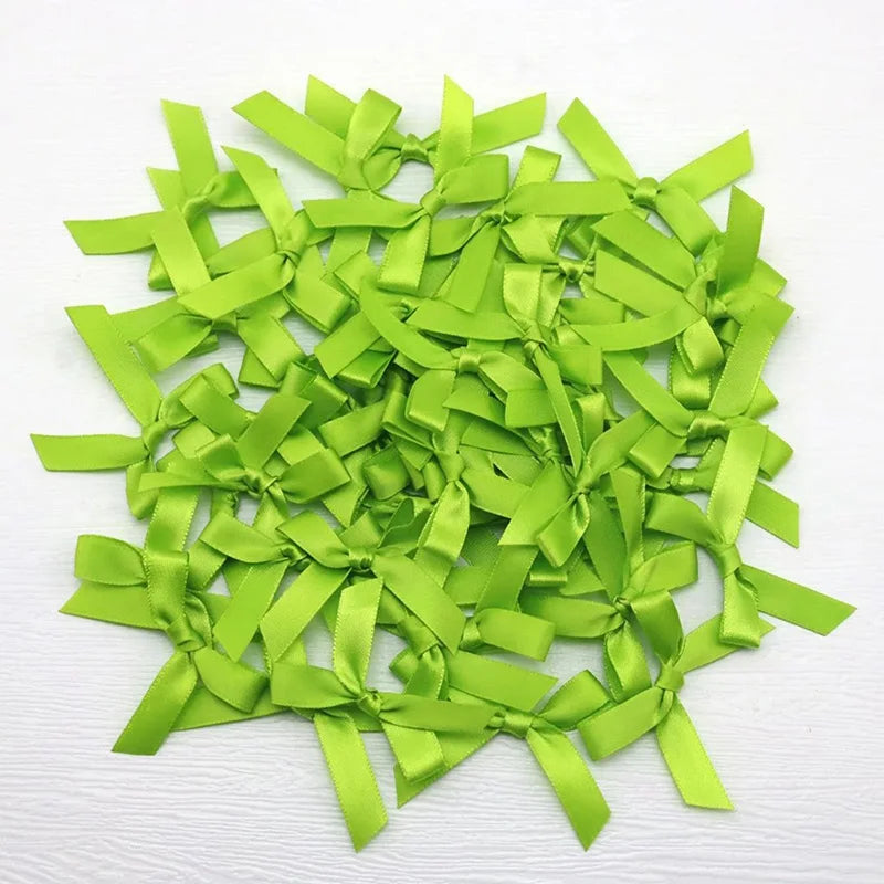 A pile of bright lime green satin ribbon bows for crafts and decor.