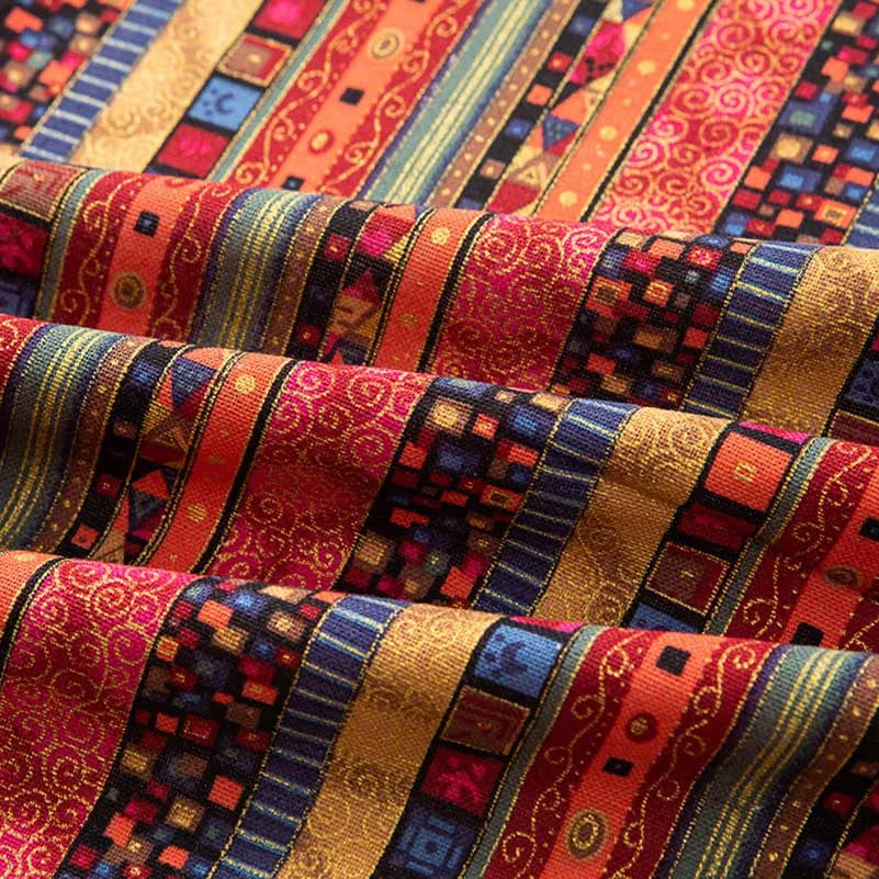 Close-up of colorful bohemian printed linen fabric featuring stripes and geometric patterns in shades of red, orange, purple,