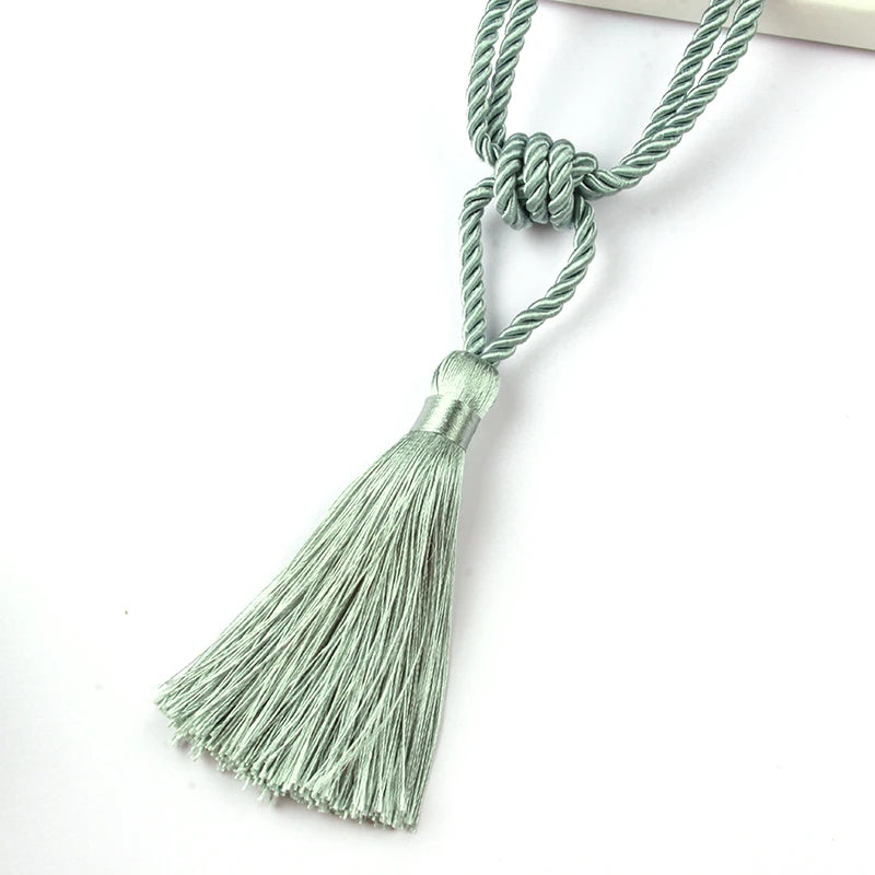Elegant curtain tiebacks made of green cord with decorative tassels