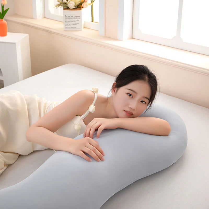 A woman rests her head on a light blue ergonomic double wave curve pillow indoors.