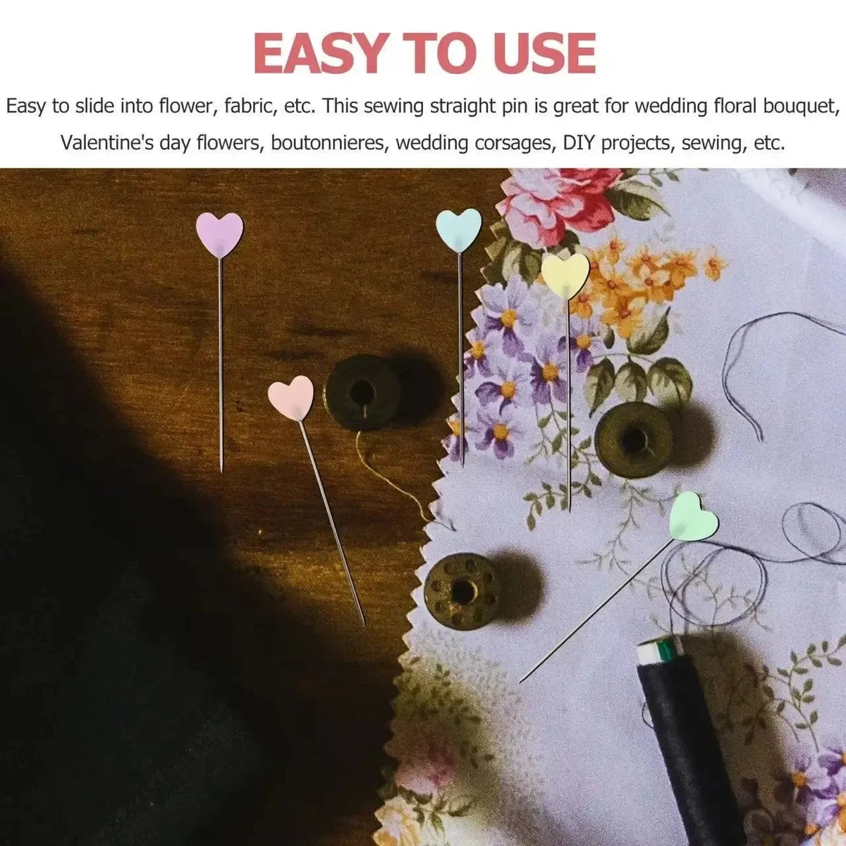 A collection of heart-shaped sewing pins in various pastel colors, including pink and green, laid out on a floral fabric.