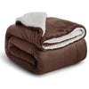 A dark brown sherpa fleece blanket rolled up, showing a white fluffy lining.