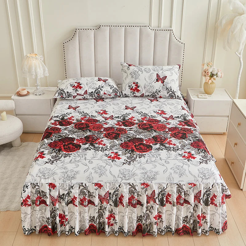 A bed featuring a floral ruffle skirt set with red and black roses on a white background.