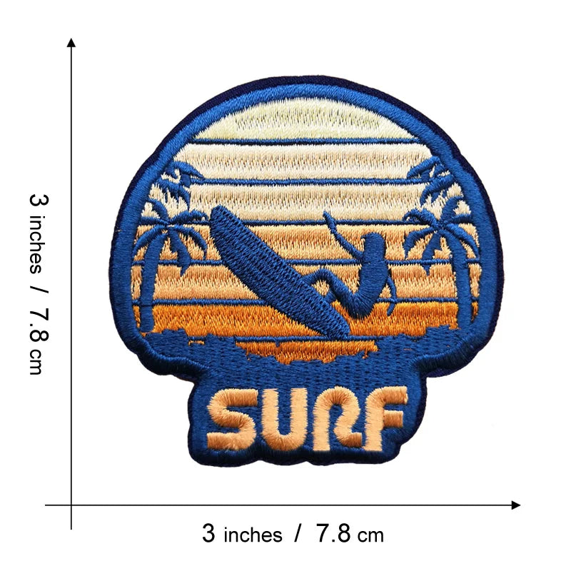 An embroidered patch featuring a silhouette of palm trees and a wave against a sunset background with the word SURF below.