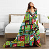 A woman is smiling while lying on a bed with a colorful patterned coral fleece throw blanket draped over her.