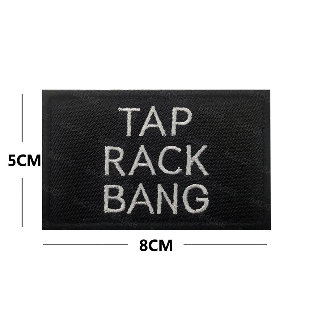 Black embroidered patch with white text reading TAP RACK BANG