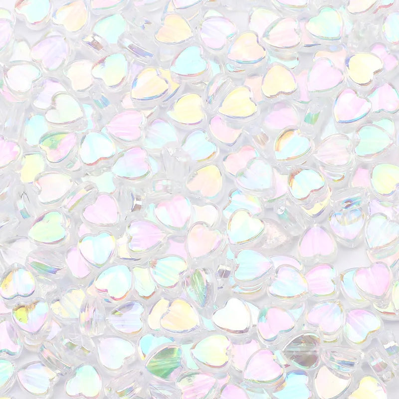 A close-up view of a 100-pack of iridescent, heart-shaped acrylic beads for jewelry making.