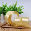 Roll of 4 cm wide satin ribbon in gold color for gift wrapping and DIY crafts