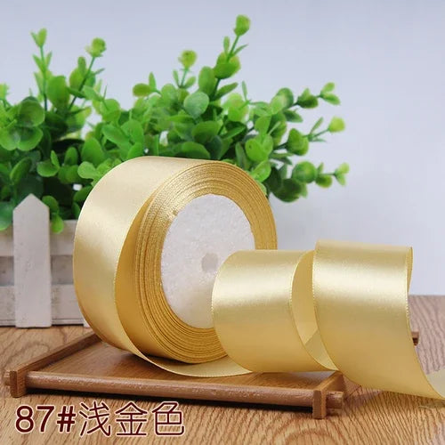 Roll of 4 cm wide satin ribbon in gold color for gift wrapping and DIY crafts