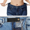 A close-up of a black elastic belt extender being placed inside the waistband of blue denim jeans.