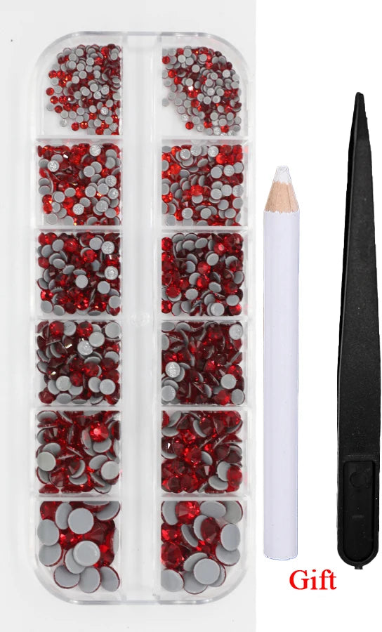 A clear plastic case containing various red and silver crystal rhinestones and an applicator tool for crafting