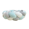 A handmade knotted floor mat for bed decor made of soft, pastel-colored wool.