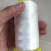 A hand is holding a spool of white high tenacity polyester sewing thread with yellow plastic caps.