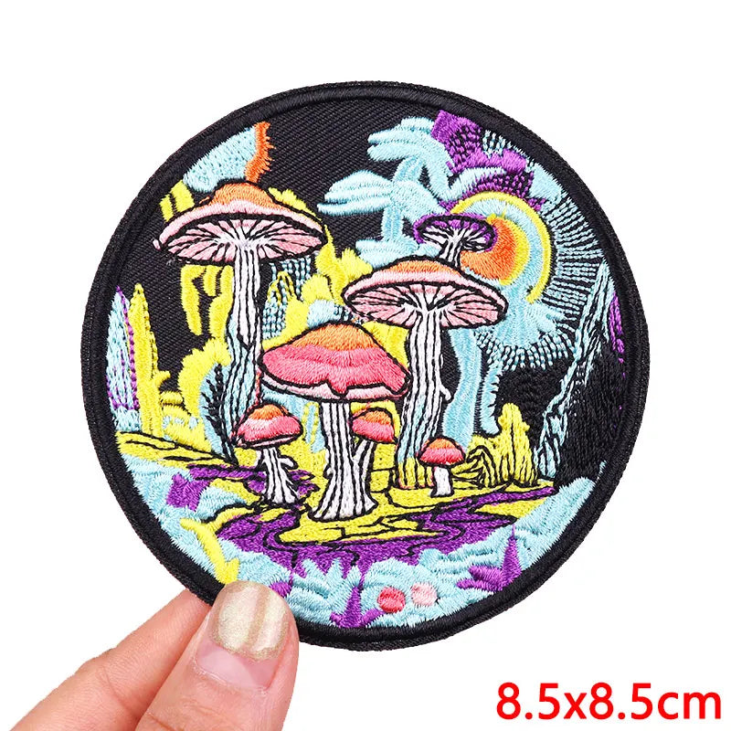 Colorful embroidered patch featuring mushrooms and foliage on a black fabric background