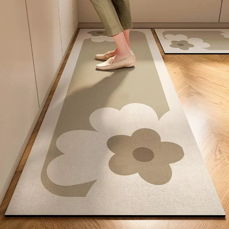 A beige kitchen floor mat with a large floral design is placed on a light wood floor.
