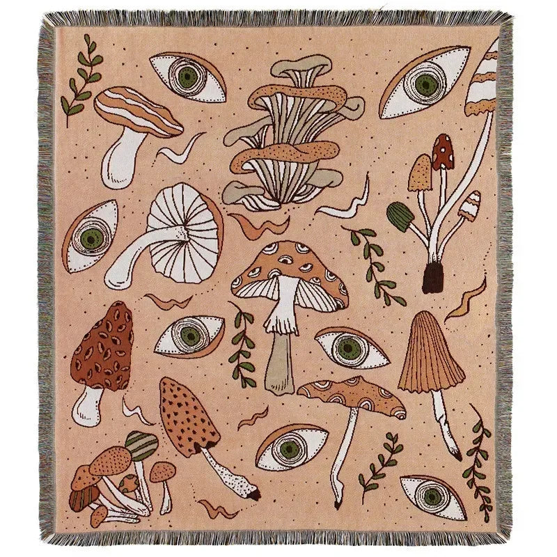A beige throw blanket featuring a pattern of stylized mushrooms and eyes in earthy tones.