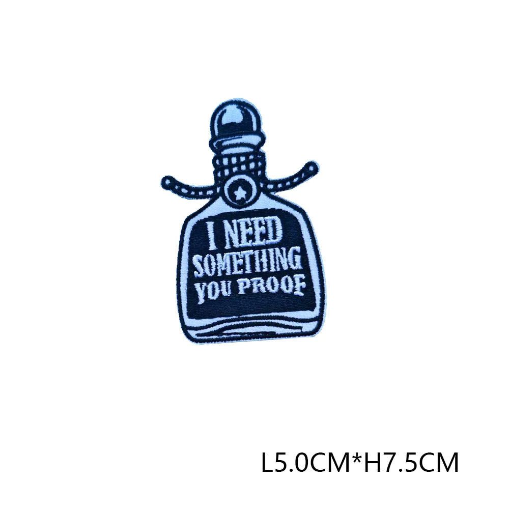 A dark blue iron-on embroidered letter patch shaped like a bottle with a stopper and a string.