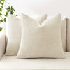 A beige linen textured throw pillow resting on a light-colored sofa.