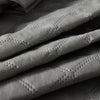 Close-up of a gray waterproof quilted mattress protector fabric texture.