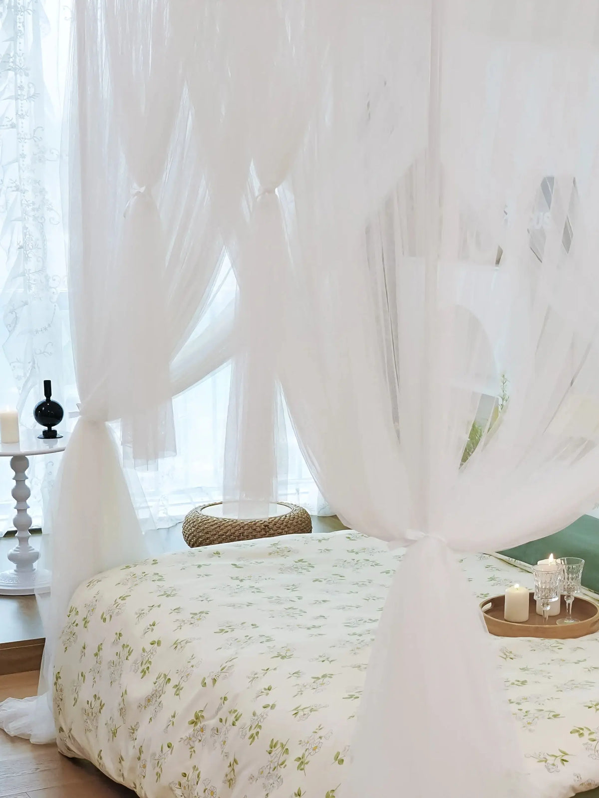 Elegant mosquito net bed canopy with sheer white fabric draped over a bed.