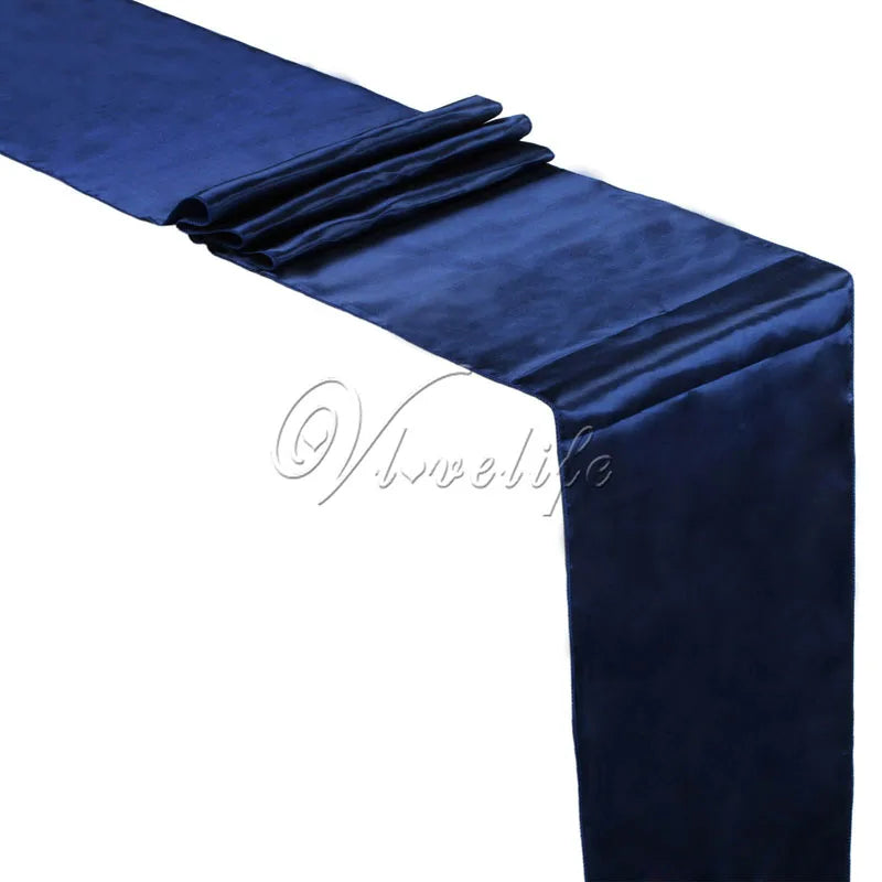 A dark blue luxury satin table runner draped and folded for events.