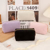 A collection of purple, pink, and cream velvet cosmetic storage pouches displayed in front of a sign reading PLACE(1409).