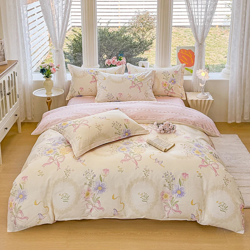 A light pink and cream 3-piece cotton duvet cover and pillow set displayed on a bed with sheer curtains.