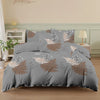 A gray duvet cover featuring a botanical print of white and copper-toned foliage on a bed.