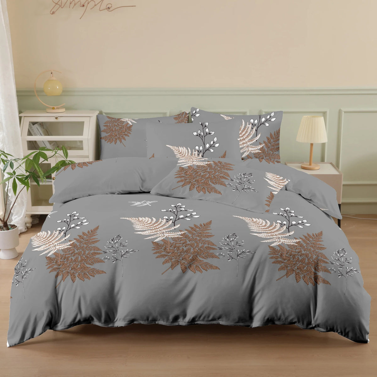 A gray duvet cover featuring a botanical print of white and copper-toned foliage on a bed.