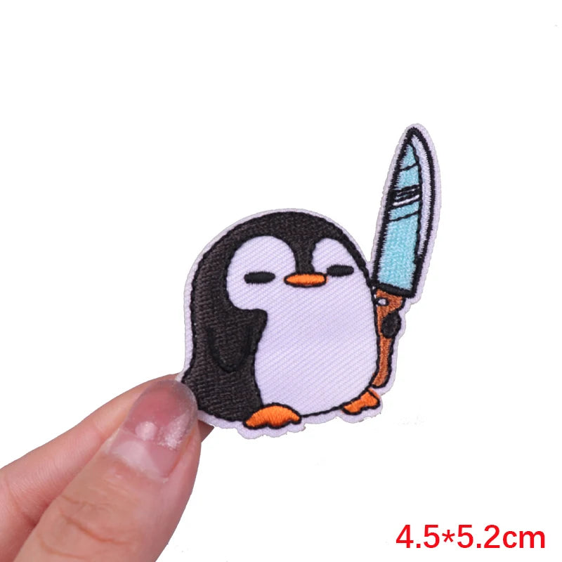 An embroidered patch of a cartoon penguin with black and white markings and orange feet.