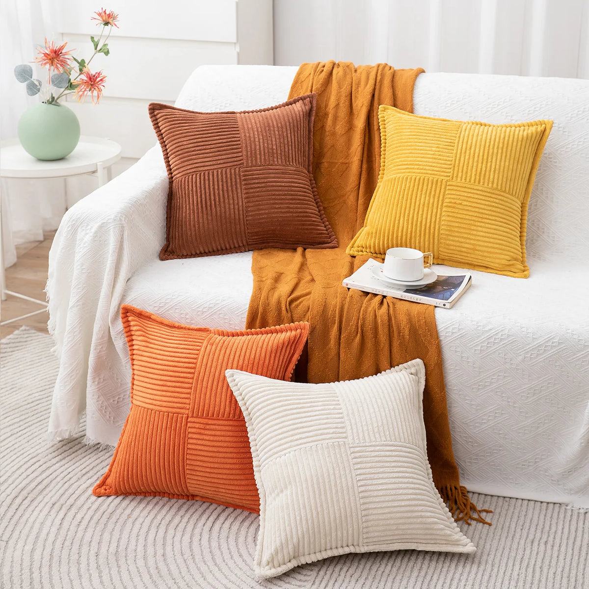 A collection of striped corduroy lumbar support pillow cushions in shades of orange, brown, and yellow arranged on a white so