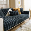 A dark gray plush rabbit sofa cushion draped over a white sofa with yellow accents.