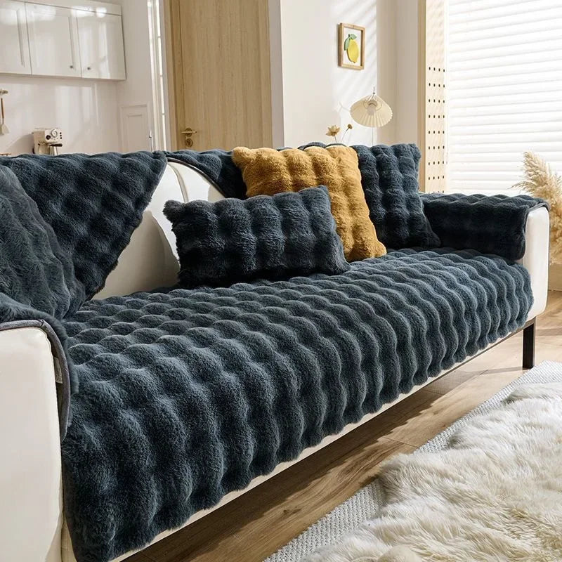 A dark gray plush rabbit sofa cushion draped over a white sofa with yellow accents.